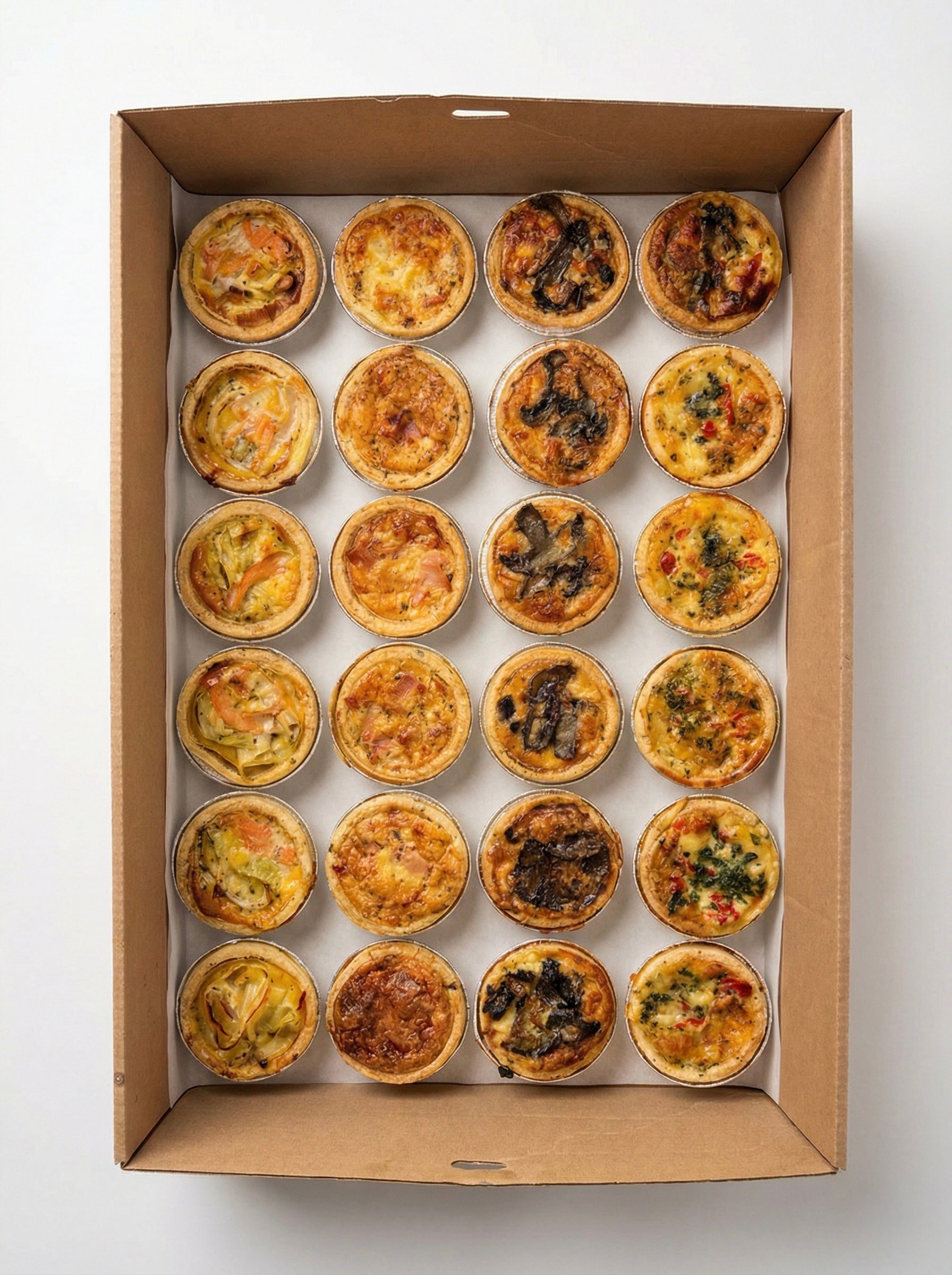 Hand-crafted mini savoury quiches with seasonal French ingredients for office lunch and event platters.